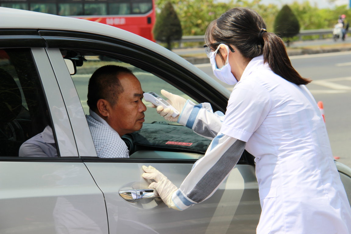 Cán bộ y tế đo thân nhiệt tại điểm giám sát y tế thuộc địa bàn quận Cái Răng