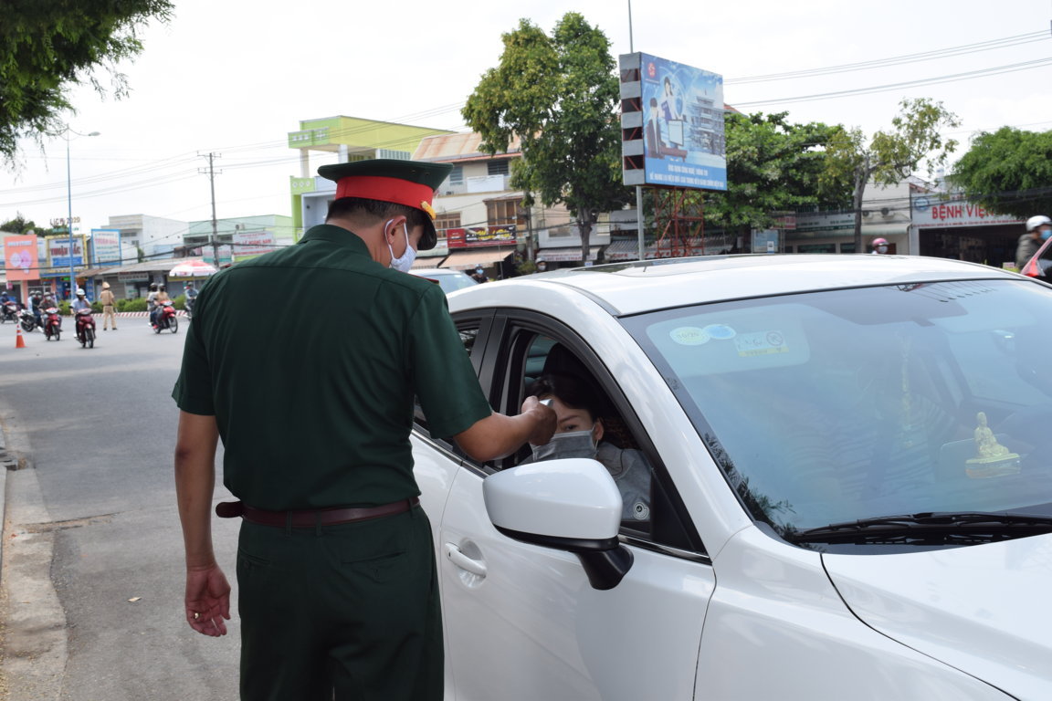 Bệnh nhân đến khám bệnh được kiểm tra thân nhiệt, thực hiện sàng lọc, phân loại, phân luồng tại Trung tâm Y tế quận Cái Răng. Ảnh: Thiên Thanh.