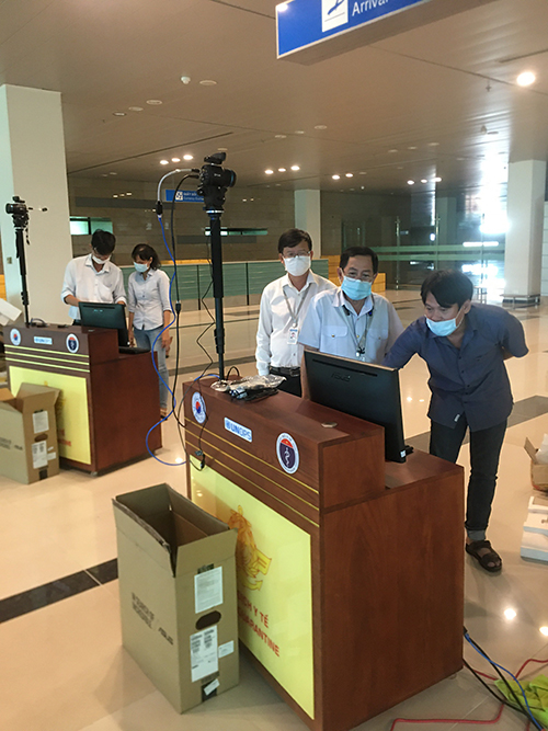 Nhân viên công ty lắp đặt và hướng dẫn sử dụng thiết bị máy đo thân nhiệt từ xa cho cán bộ Tổ kiểm dịch y tế, CDC Cần Thơ tại Cảng Hàng không quốc tế Cần Thơ
